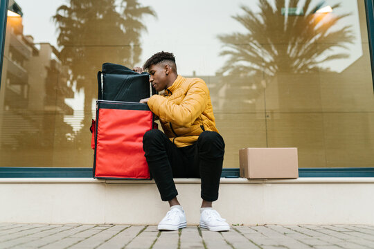 Male courier checking goods in backpack