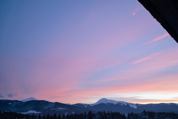 Snowy mountain hills covered with coniferous trees