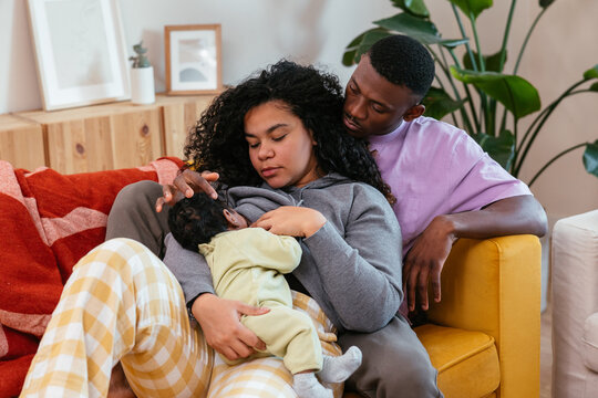 Parents with baby resting on couch