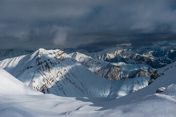 Snowy winter mountains in sun day. Georgia, from ski resort Gudauri.