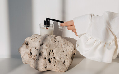 Anonymous woman extinguishing burning aromatic candle