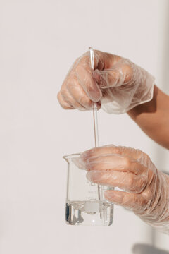 hands mixing liquid in measuring-glass