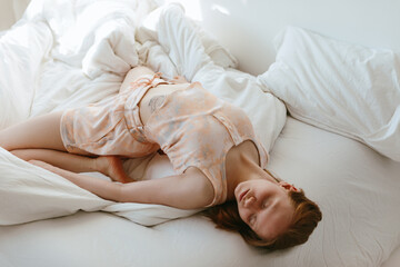 Woman in sleepwear lying on bed