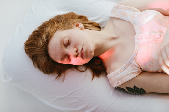 Gentle redhead woman portrait lying on bed