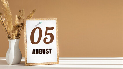 august 5. 5th day of month, calendar date.White vase with dead wood next to cork board with numbers. White-beige background with striped shadow. Concept of day of year, time planner, summer month