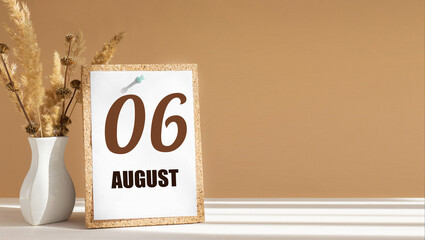 august 6. 6th day of month, calendar date.White vase with dead wood next to cork board with numbers. White-beige background with striped shadow. Concept of day of year, time planner, summer month