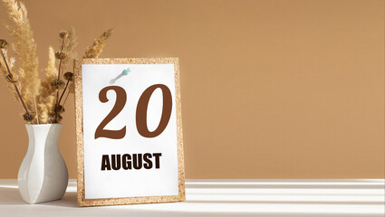 august 20. 20th day of month, calendar date.White vase with dead wood next to cork board with numbers. White-beige background with striped shadow. Concept of day of year, time planner, summer month