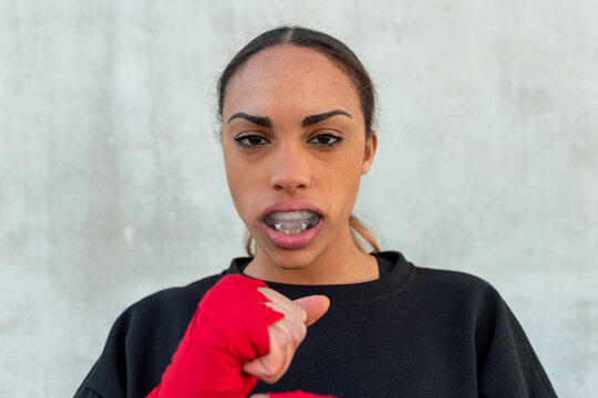 Confident female boxer in mouth guard during training
