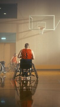 Vertical Video. Wheelchair Basketball Game: Professional Players Competing, Dribbling Ball, Passing, Shooting and Scoring a Goal. Celebration of People with Disability. Stylish Cinematic Slow Motion