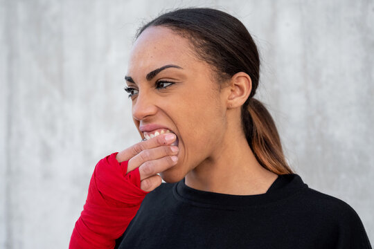Sportswoman putting on mouth guard before training