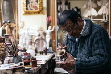 Senior ceramic artist working in his workshop