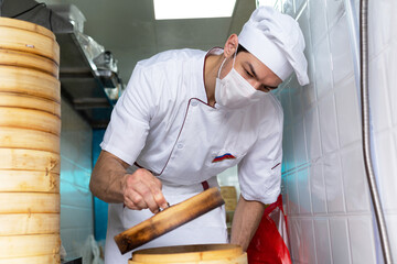 Portrait of professional chef making fresh dumplings in the restaurant.