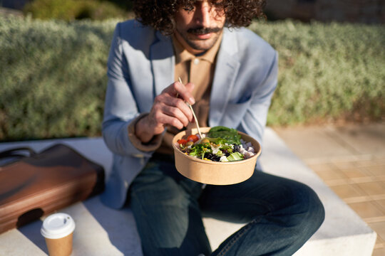 Male freelancer having lunch in park