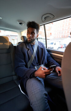 Male entrepreneur using smartphone in car