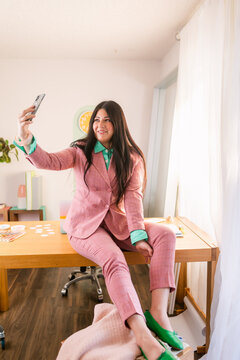 Trendy businesswoman making zoom in cozy office