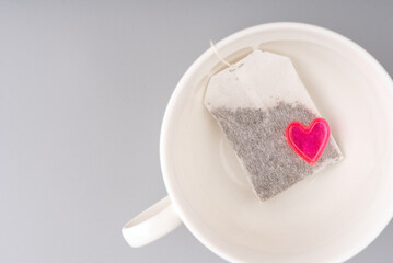 Concept I love tea. The heart lies on a tea bag in a cup. Space for text
