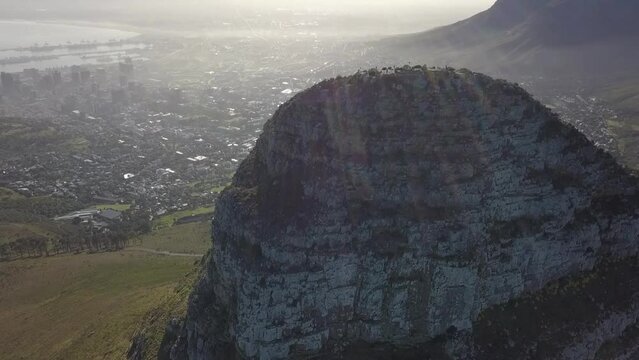 Lens flare hazy city aerial retreats from Lion's Head peak, Cape Town