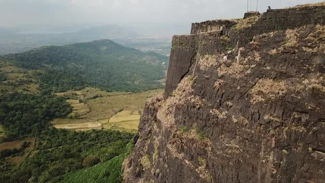 Aerial flight to end of Vinchu Kada hill fort high above Indian farms