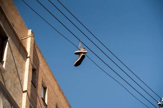 Pair of Shoes hanging from  electric line in the city