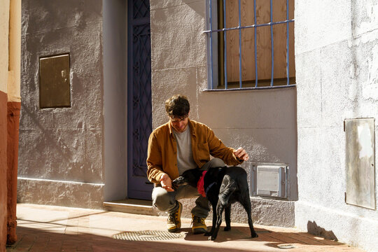 Happy confident man hugging dog in the city