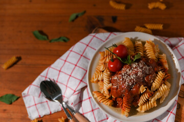 Top view, Homemade fusilli pasta with tomato sauce on a wood dining table.