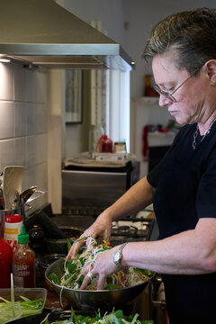 Home cook mixing noodle salad 