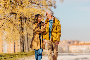 Cheerful senior couple standing in autumn park