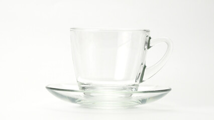 Pouring hot tea into transparent glass on white background. Closeup view of hot tea being poured in a cup on white.