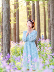 Portrait of elegant Chinese girl in dress enjoy carefree time in forest park in sunny day. Outdoor fashion portrait of glamour young Chinese cheerful stylish woman.