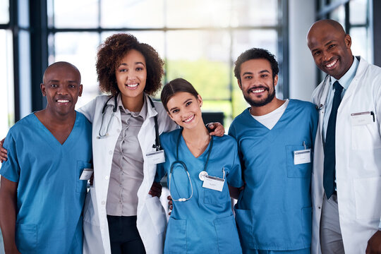 They Started From The Bottom And Went To The Top. Portrait Of A Cheerful Group Of Doctors Standing With Their Arms Around Each Other Inside Of A Hospital During The Day.