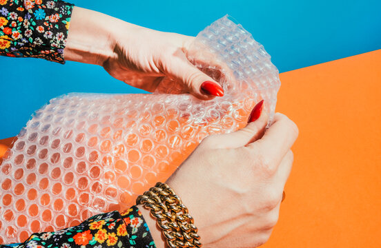 Hands popping bubble wrap