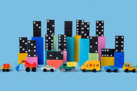 Сolored cubes with domino over it and toy cars near