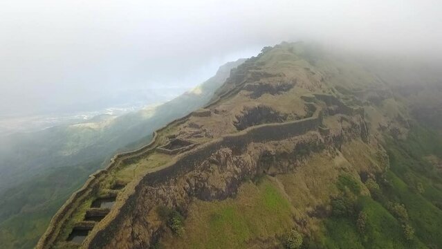 Aerial view of remote Indian hilltop medieval Torna Fort through cloud