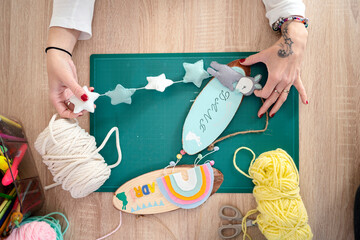 Crop lady creating hanging decoration for kids room