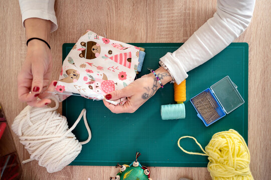 Crop seamstress sewing toy at wooden desk
