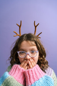 Shocked girl covering mouth in studio