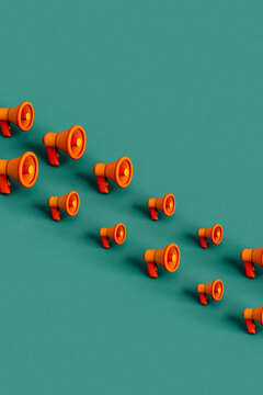 rows of Orange megaphones on green. 3d render