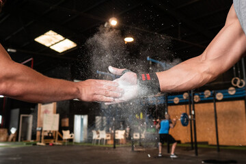 Crop anonymous athletes bumping fists during workout