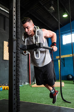 Strained man exercising with chain on neck