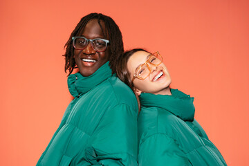 Smiling multiracial teenage models in similar warm wear