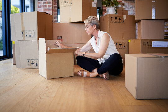 My home, my heart. Shot of a mature woman unpacking boxes on moving day.