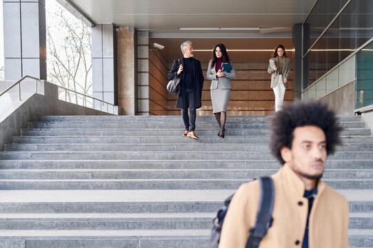 Businesspeople talking while leaving their office