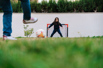 Brave girl protecting football goal from attack while