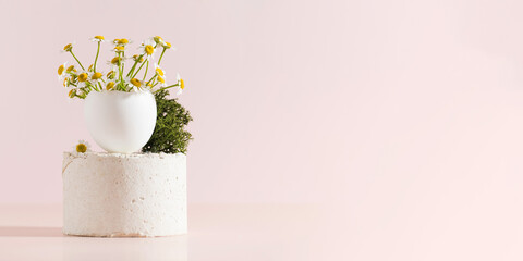 Spring and Easter concept, a bouquet of eggshell daisies on a podium on a light pink background. Art