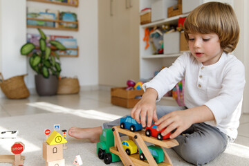 A boy is playing with toy cars