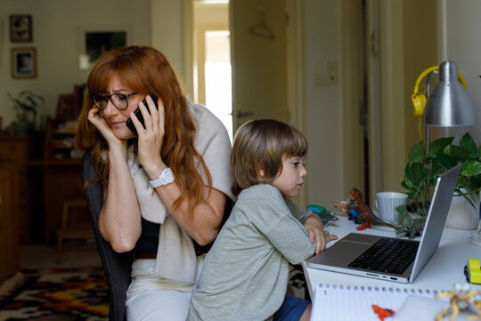 Working mom from home talking on a phone