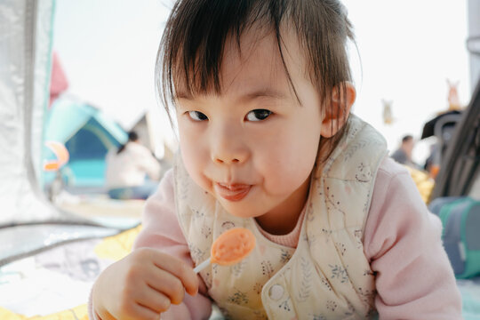 Asian baby eating lollipop