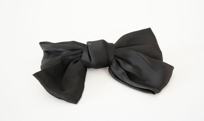 Black cute silk bow. Barrette. Isolated on a white background. Horizontal format