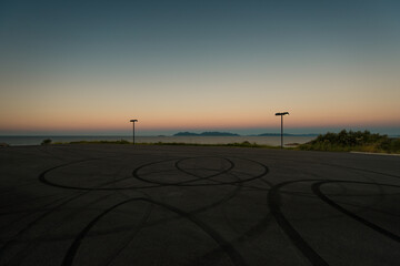 Parking lookout with asphalt tire marks at sunset