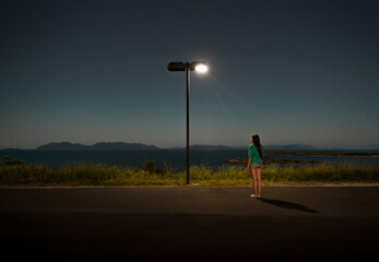 Anonymous woman looking at streetlight 